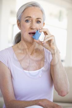 Royalty Free Photo of a Woman Using an Inhaler