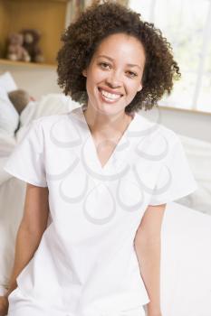 Royalty Free Photo of a Nurse Sitting on a Hospital Bed