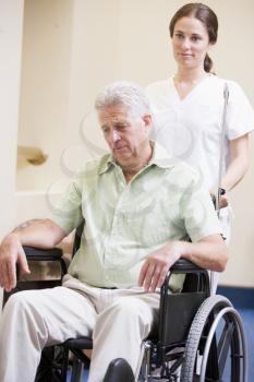 Royalty Free Photo of a Nurse Pushing a Man in a Wheelchair