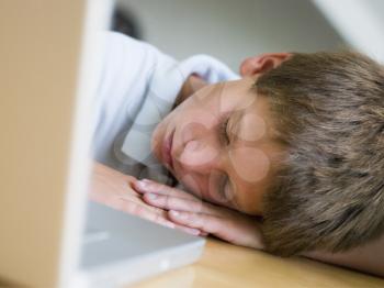 Royalty Free Photo of a Young Boy Asleep Beside His Laptop