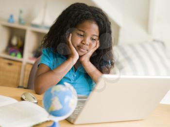 Royalty Free Photo of a Girl Doing Homework With a Laptop
