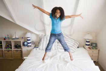 Royalty Free Photo of a Girl Jumping on Her Bed