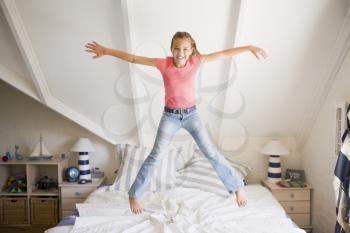 Royalty Free Photo of a Girl Jumping on a Bed