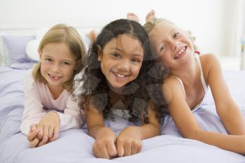 Royalty Free Photo of Three Girls in PJs on a Bed