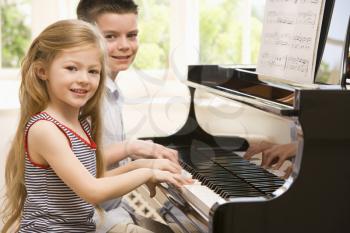 Royalty Free Photo of a Brother and Sister Playing Piano