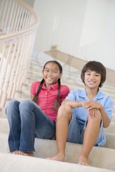 Royalty Free Photo of a Girl and Boy Sitting on the Stairs