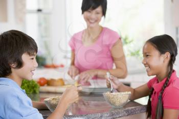 Royalty Free Photo of Children Having Breakfast With Mom in the Kitchen