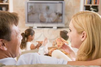 Royalty Free Photo of a Couple Watching TV and Eating Pizza