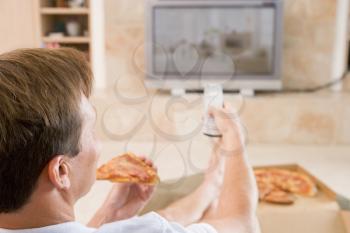 Royalty Free Photo of a Man Eating Pizza and Watching TV