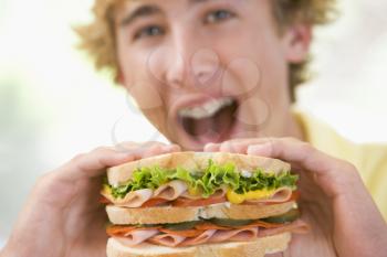 Royalty Free Photo of a Boy Eating a Sandwich
