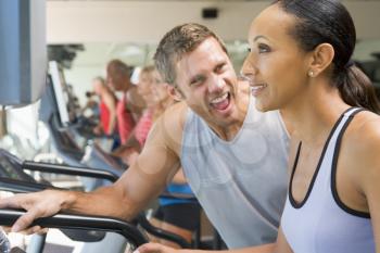 Royalty Free Photo of a Personal Trainer Encouraging a Woman on a Treadmill