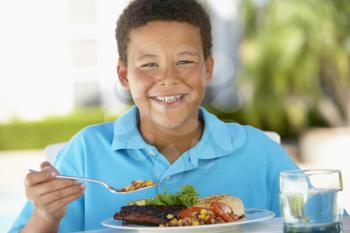 Royalty Free Photo of a Boy Eating Outside