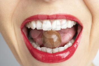 Royalty Free Photo of a Woman With Chocolate in Her Mouth