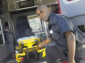 Royalty Free Photo of a Paramedic Removing an Empty Gurney From an Ambulance