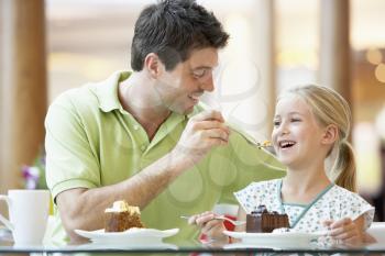 Royalty Free Photo of a Father and Daughter Having Cake at a Mall