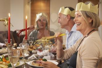 Royalty Free Photo of Friends Wearing Party Hats at a Dinner Party