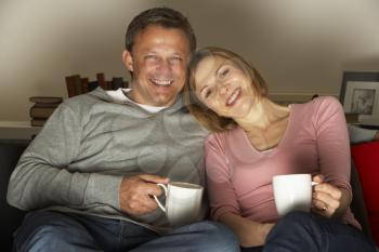 Royalty Free Photo of a Couple With Coffee Watching TV