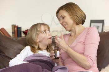 Royalty Free Photo of a Mother Giving Her Daughter Medicine