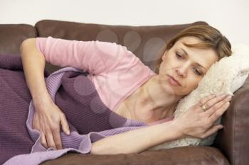 Royalty Free Photo of a Woman Lying on a Sick Woman on the Couch