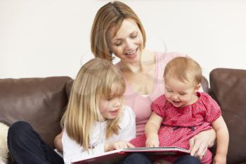 Royalty Free Photo of a Mother Reading to Her Daughters