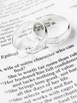 Royalty Free Photo of Silver Wedding Rings on a Page of the Bible
