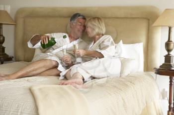 Royalty Free Photo of a Couple in Bed With Champagne