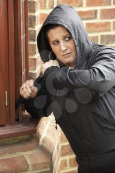 Royalty Free Photo of a Young Woman Breaking Into a House