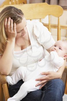 Royalty Free Photo of a Worried Mother in a Nursery With a Baby