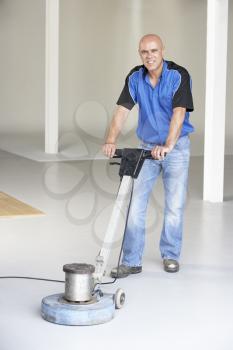 Royalty Free Photo of a Man Cleaning an Office Floor