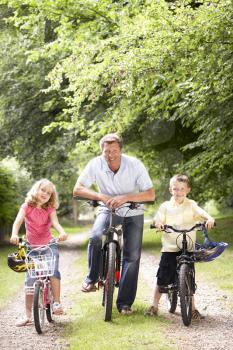 Royalty Free Photo of a Father Riding Bikes With His Children