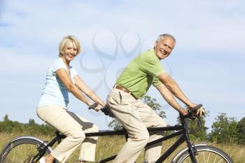 Royalty Free Photo of a Couple Riding a Tandem Bike