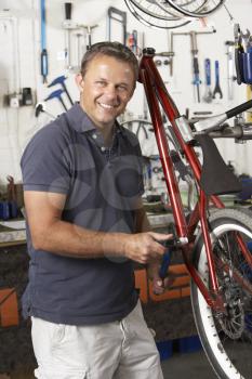 Royalty Free Photo of a Man Fixing His Bike