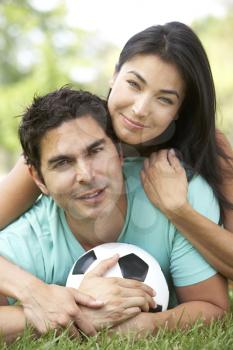 Royalty Free Photo of a Couple on the Ground With a Soccer Ball