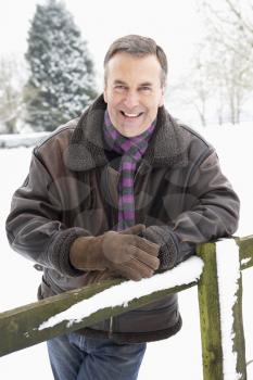 Senior Man Standing Outside In Snowy Landscape