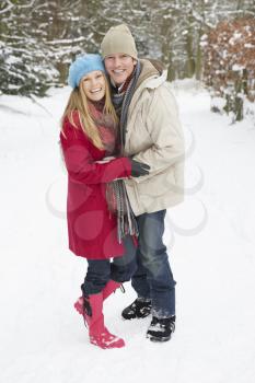 Couple Walking Through Snowy Woodland
