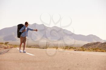 Man On Vacation Hitchhiking Along Country Road