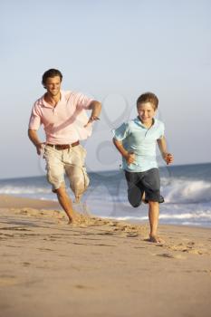 Father And Son Running Along Summer Beach