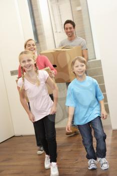 Family happy on moving day carrying cardboard boxes