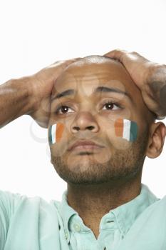Disappointed Young Male Sports Fan With Ivory Coast Flag Painted On Face