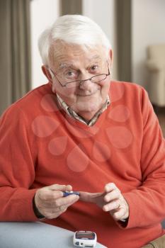 Senior Man Checking Blood Sugar Level At Home