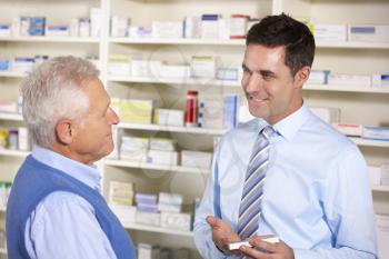UK pharmacist serving  senior man in pharmacy