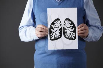 Senior man holding ink drawing of lungs