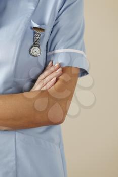 UK nurse standing with arms folded