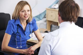 Female UK doctor talking to male patient