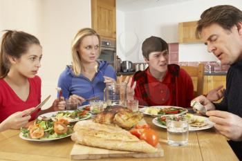Teenage Family Having Argument Whilst Eating Lunch Together In Kitchen