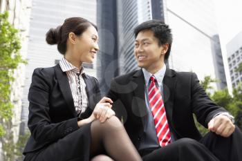 Chinese Businessman And Businesswoman Talking Outside Office