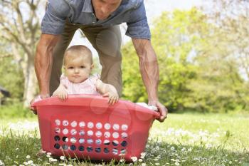 Father Carrying Baby Girl Sitting In Laundry Basket