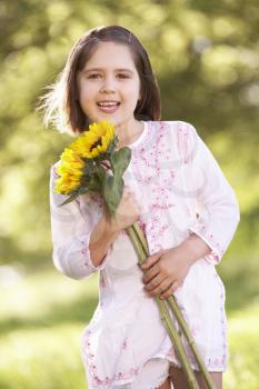Young Girl Walking Through Summer Field Holding Sunflower