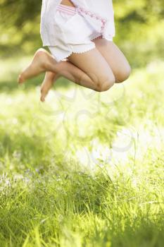 Close Up Of Young Girl Jumping In Summer Field