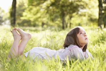 Young Girl Daydreaming Lying In Summer Field